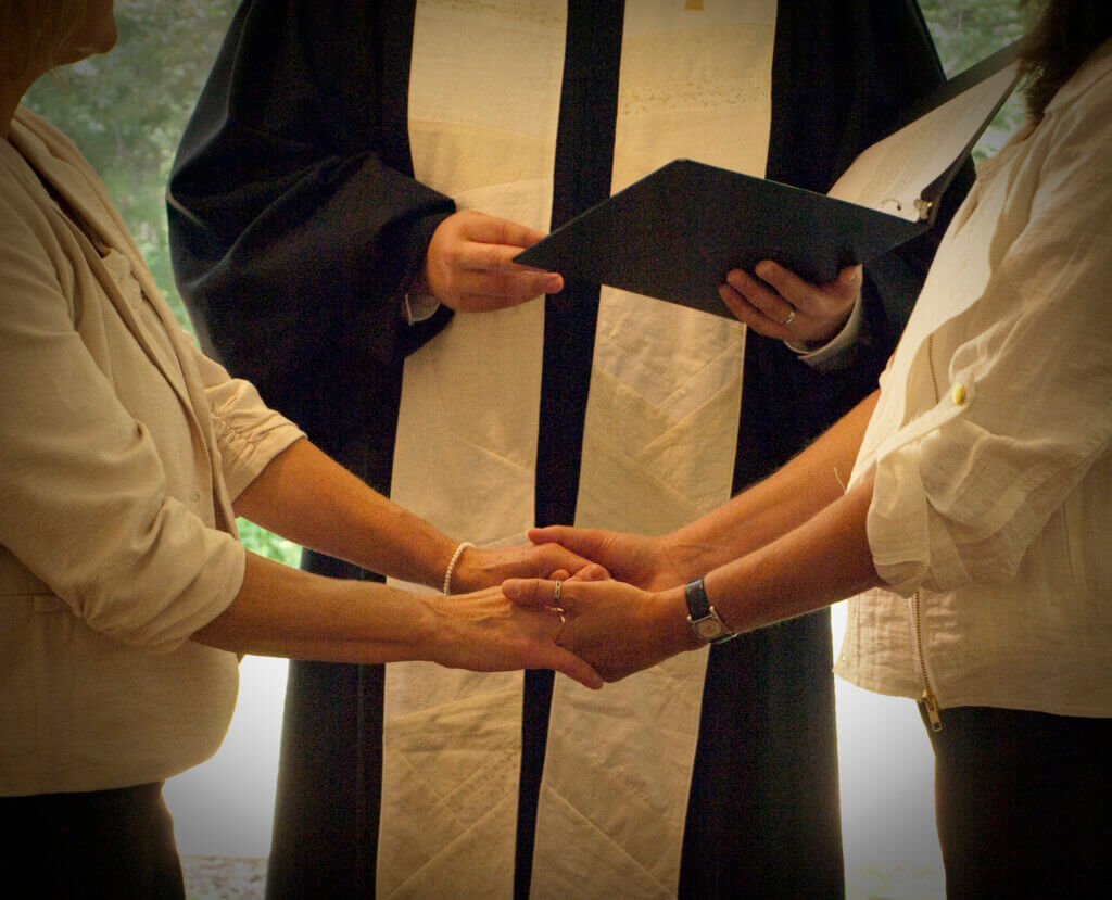 a couple holding hands during a wedding ceremony