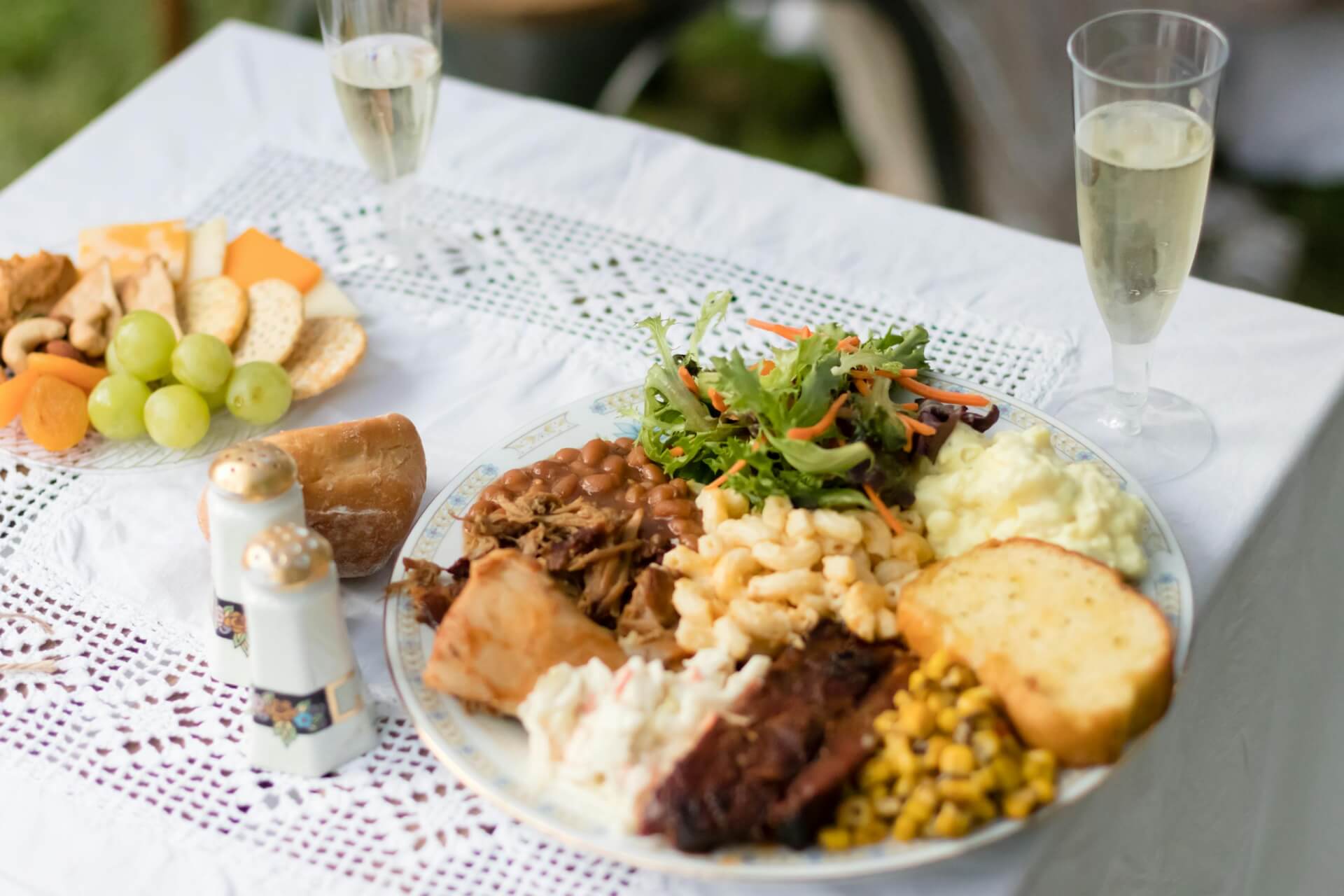 A gourmet dinner setting with diverse food selection on an elegant outdoor table.